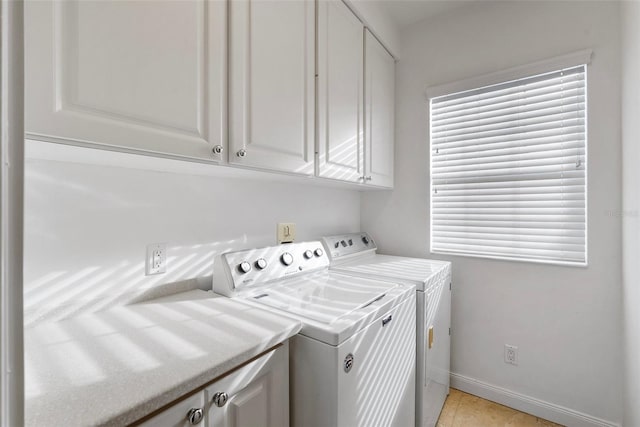 laundry area featuring separate washer and dryer, light tile patterned flooring, and cabinets