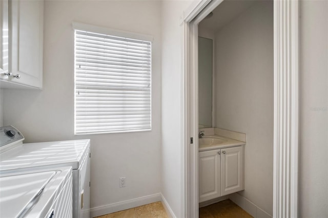 washroom with cabinets, light tile patterned floors, separate washer and dryer, and sink