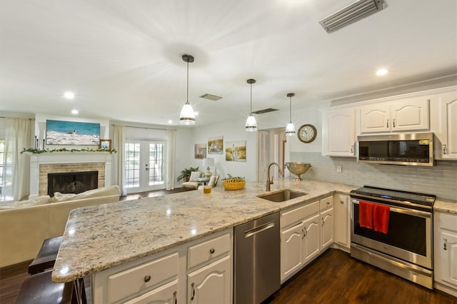 kitchen featuring hanging light fixtures, white cabinetry, sink, and appliances with stainless steel finishes