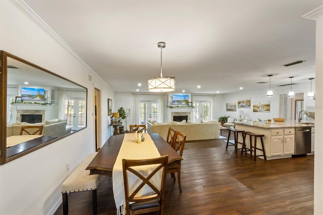 dining space featuring sink, crown molding, and dark wood-type flooring