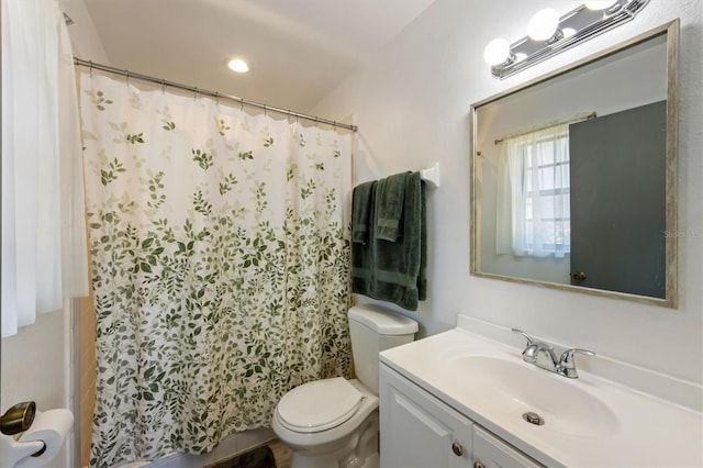 bathroom featuring curtained shower, vanity, and toilet