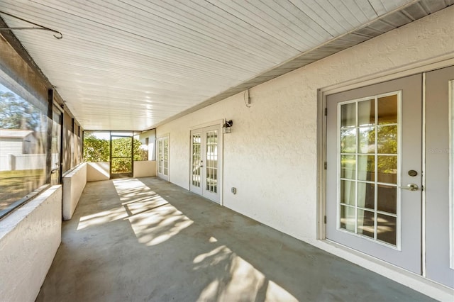 unfurnished sunroom featuring french doors, wooden ceiling, and a healthy amount of sunlight