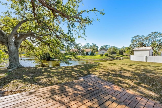 deck with a lawn and a water view