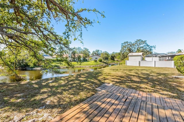 deck featuring a water view and a lawn