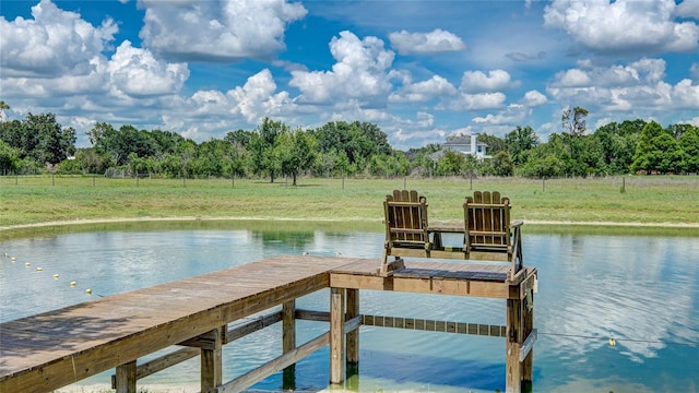 view of dock with a rural view, a water view, and a yard