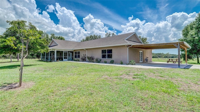 view of front of property featuring a carport, a sunroom, and a front yard