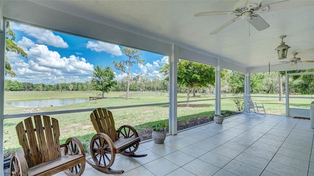 unfurnished sunroom with plenty of natural light, ceiling fan, and a water view