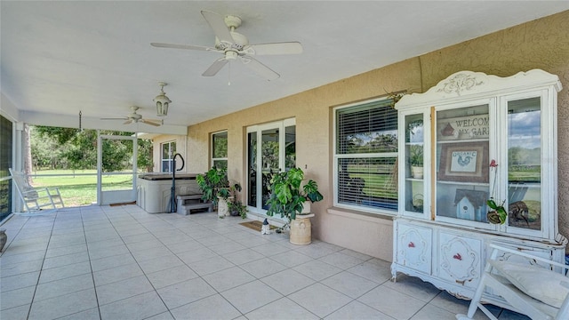 unfurnished sunroom with ceiling fan