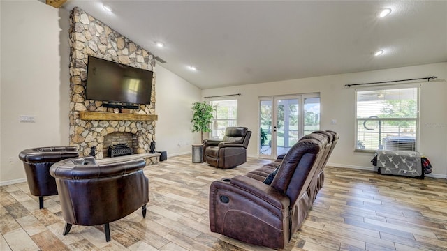 living room featuring a stone fireplace, light wood-type flooring, french doors, and vaulted ceiling