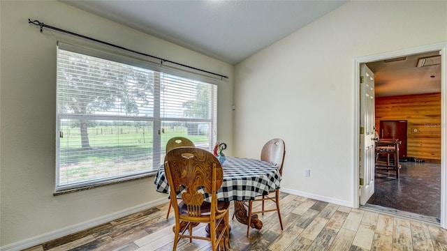 dining room with hardwood / wood-style flooring, lofted ceiling, and a wealth of natural light