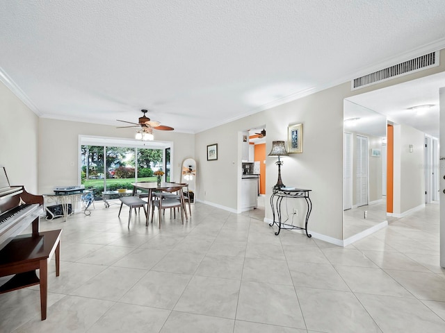 tiled dining area featuring a textured ceiling, ceiling fan, and crown molding