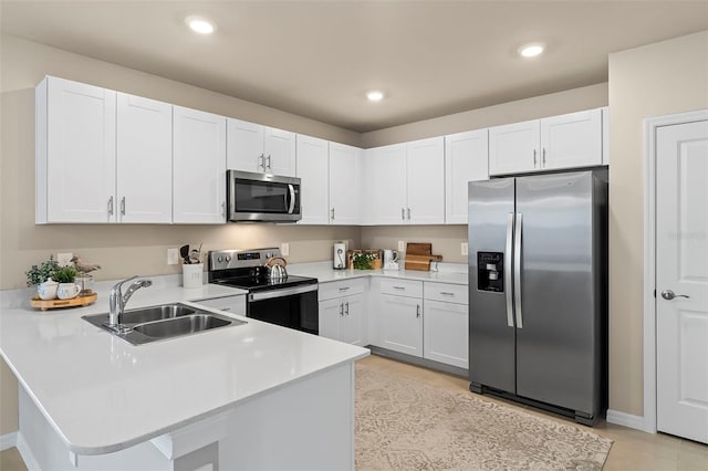 kitchen with kitchen peninsula, stainless steel appliances, white cabinetry, and sink