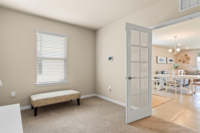 living area with french doors, carpet, a healthy amount of sunlight, and a notable chandelier