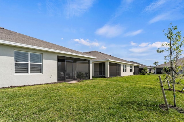 back of property with a sunroom and a yard