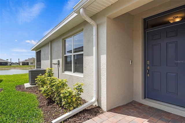 entrance to property featuring cooling unit and a water view