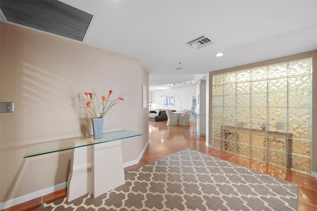 hallway with tile patterned floors and lofted ceiling