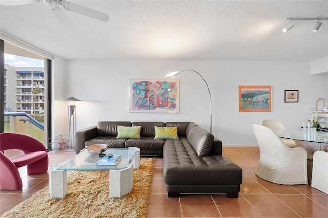 tiled living room with ceiling fan, a textured ceiling, and track lighting