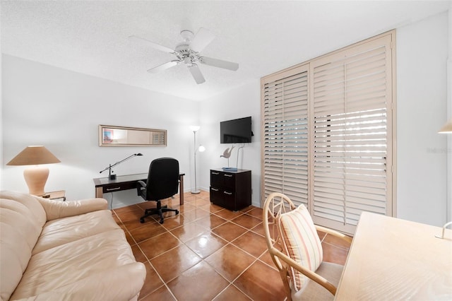 tiled office space featuring ceiling fan and a textured ceiling