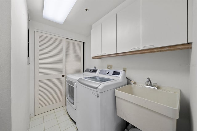 washroom with cabinets, independent washer and dryer, sink, and light tile patterned floors