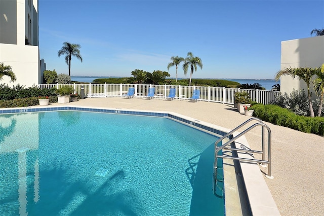 view of swimming pool featuring a water view and a patio area