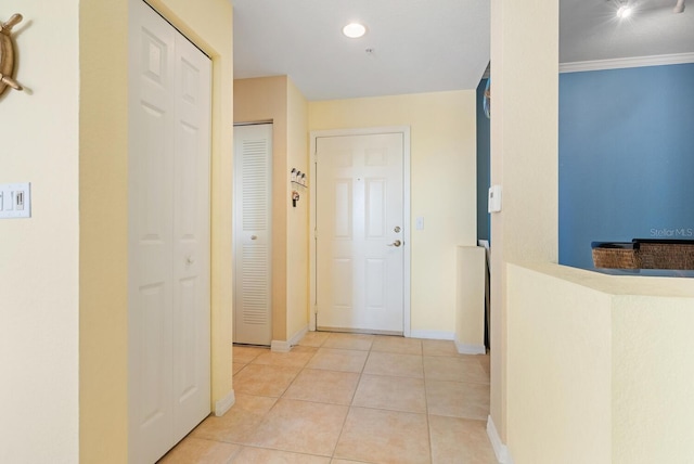 corridor featuring crown molding and light tile patterned flooring