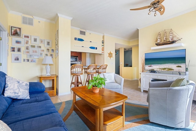 living room with light tile patterned floors, ceiling fan, and crown molding