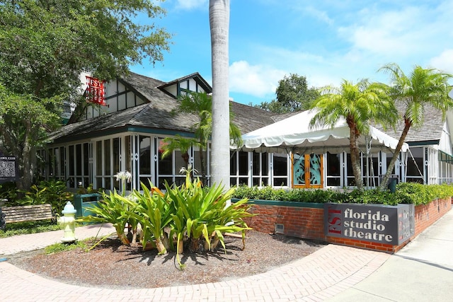 rear view of property featuring a sunroom