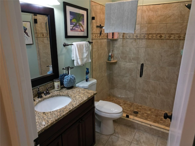 bathroom with tile patterned floors, walk in shower, vanity, and toilet