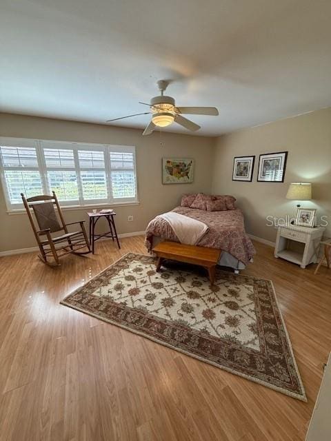 bedroom featuring ceiling fan, multiple windows, and light hardwood / wood-style flooring