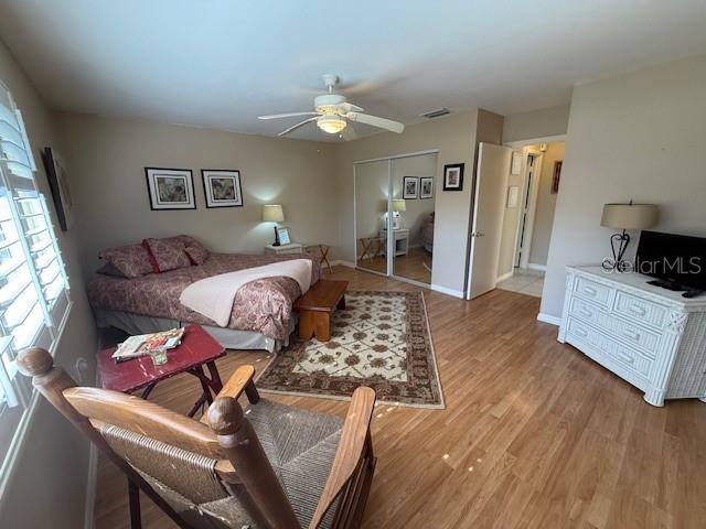 bedroom featuring hardwood / wood-style flooring, ceiling fan, and a closet