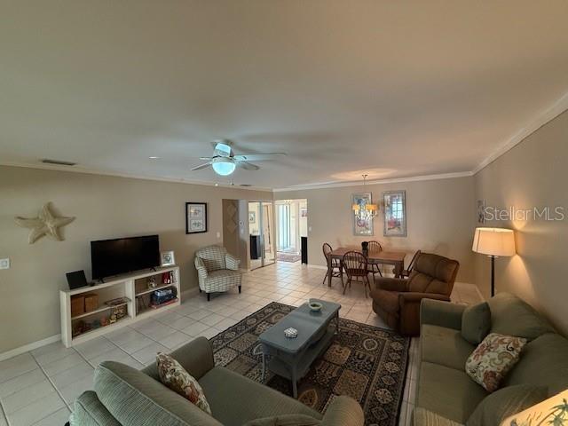 tiled living room featuring crown molding and ceiling fan