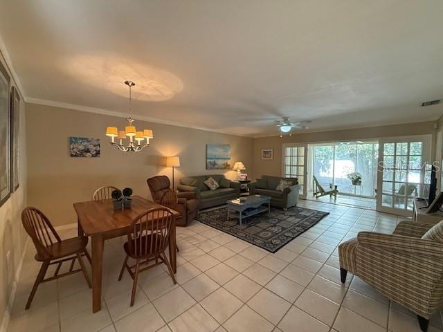 dining area with crown molding, ceiling fan with notable chandelier, and light tile patterned floors