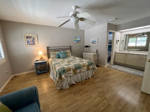 bedroom featuring ceiling fan, connected bathroom, and light hardwood / wood-style flooring