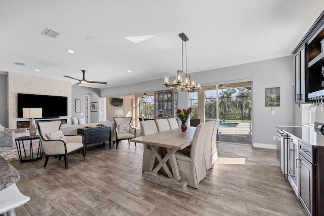 dining area featuring light hardwood / wood-style flooring and ceiling fan with notable chandelier