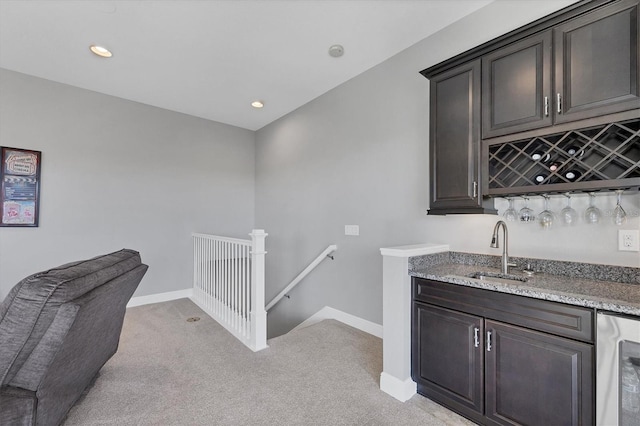 bar with light carpet, sink, and dark brown cabinets