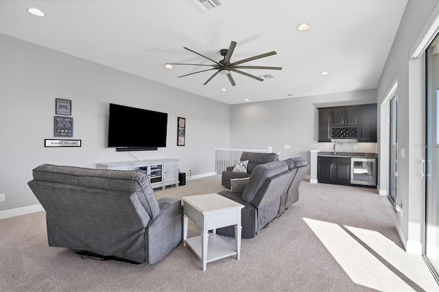 carpeted living room with wine cooler, ceiling fan, and indoor wet bar