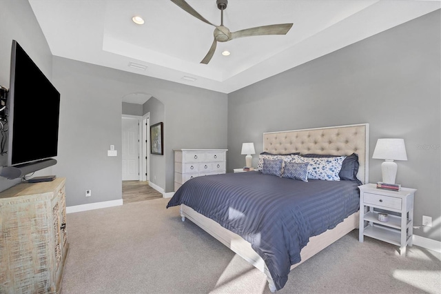 bedroom with a tray ceiling, ceiling fan, and light colored carpet