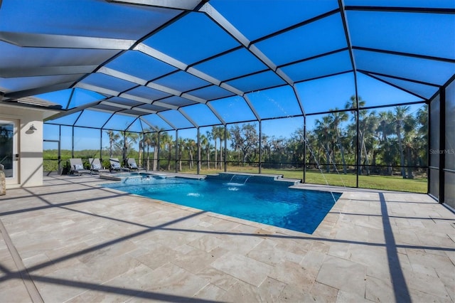 view of pool with glass enclosure, pool water feature, and a patio