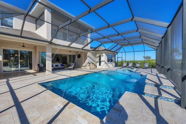 view of swimming pool featuring a lanai, pool water feature, ceiling fan, and a patio area