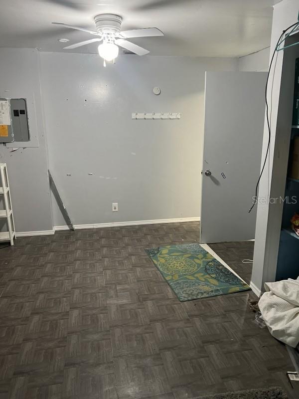 empty room featuring electric panel and ceiling fan