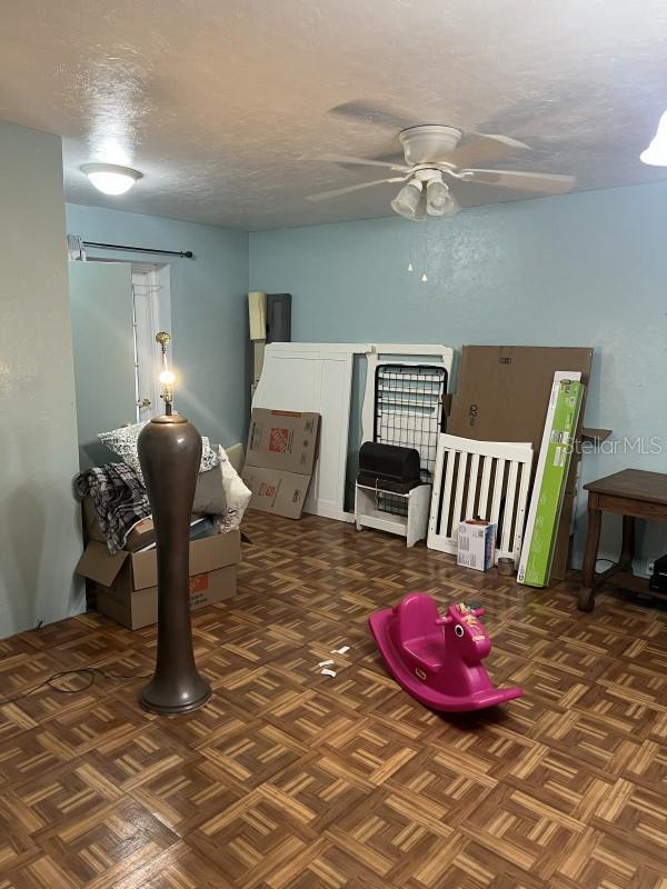 interior space featuring ceiling fan and a textured ceiling