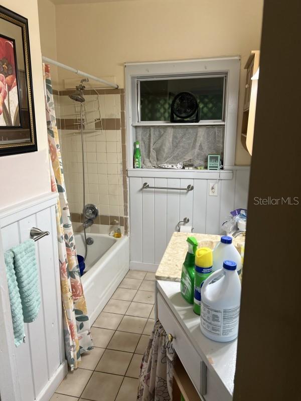 bathroom with tile patterned flooring and shower / bath combination with curtain