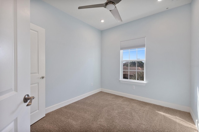 carpeted spare room featuring ceiling fan