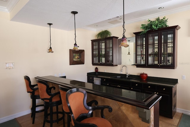 bar featuring sink, hanging light fixtures, a textured ceiling, and ornamental molding