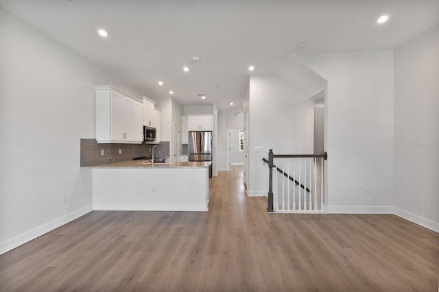 kitchen featuring white cabinets, stainless steel appliances, light hardwood / wood-style flooring, and sink