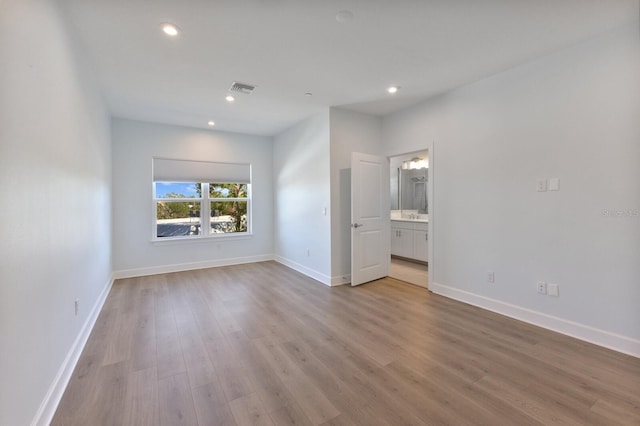 unfurnished bedroom featuring light hardwood / wood-style flooring and ensuite bath