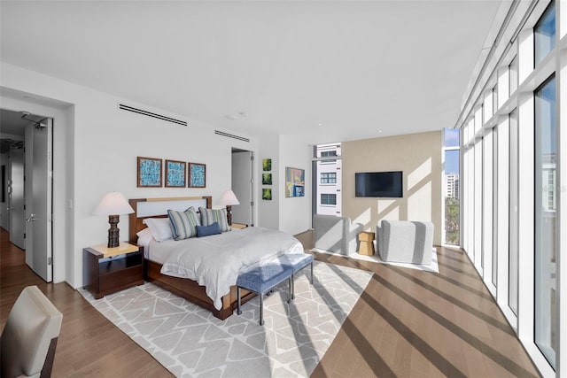 bedroom featuring light hardwood / wood-style flooring and a wall of windows