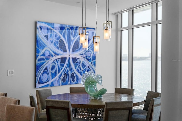 dining area featuring a water view and a wall of windows