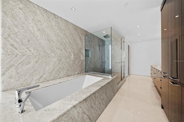 bathroom featuring tile patterned flooring, vanity, shower with separate bathtub, and tile walls