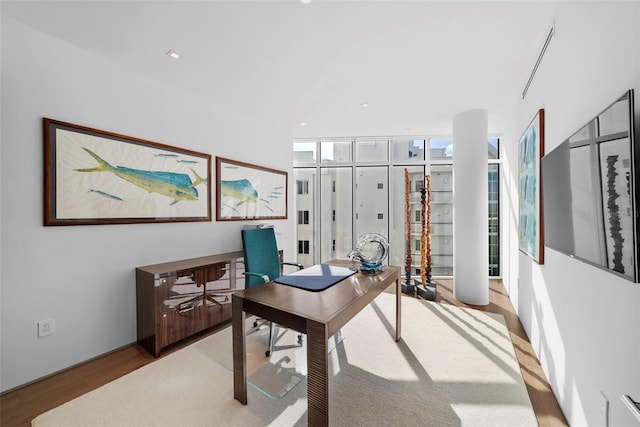 office area with light hardwood / wood-style floors and a wall of windows